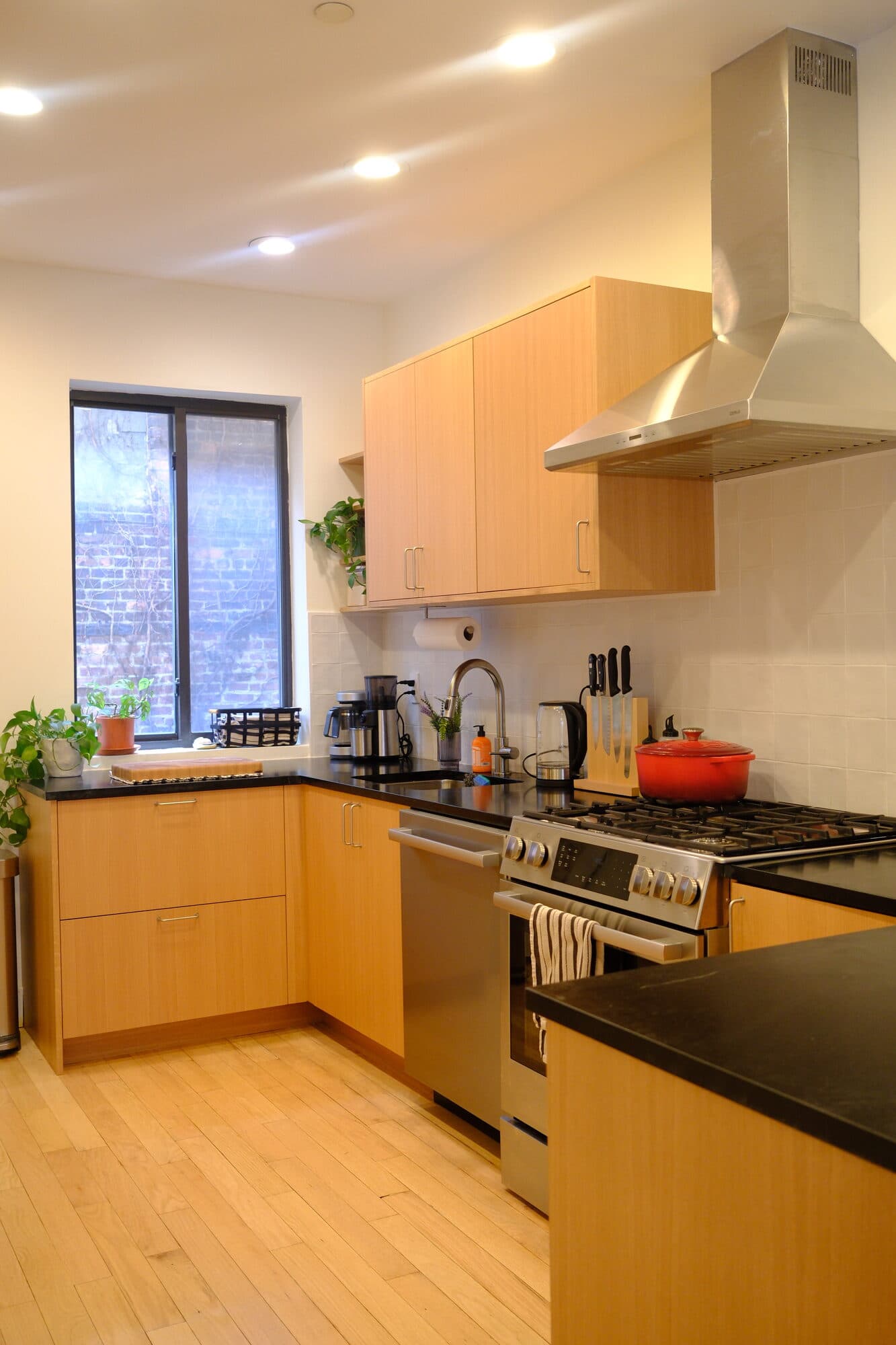 Wide view of the Greenpoint kitchen with wood-paneled accent wall and island