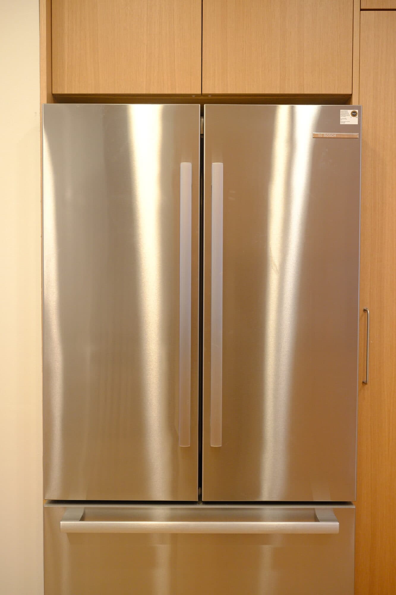 Integrated stainless refrigerator drawers flush with oak cabinet fronts