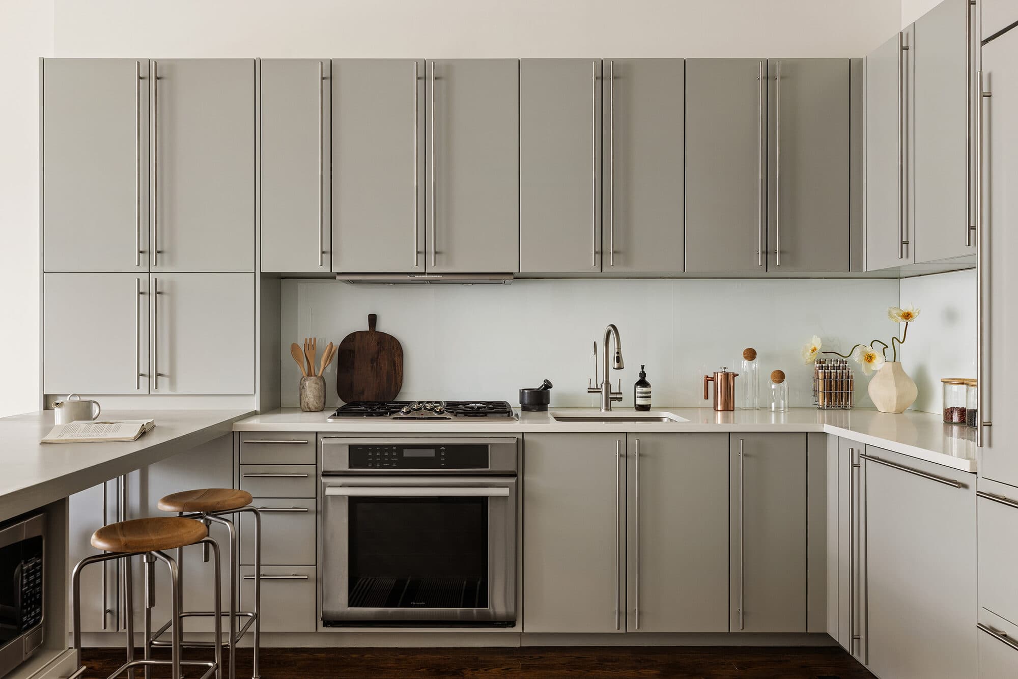 Gray flat-panel kitchen with integrated appliances and counter seating