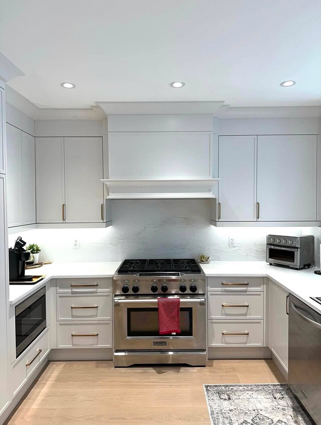 Renovated Prospect Heights kitchen with white shaker cabinets, brass hardware, and pro-style range