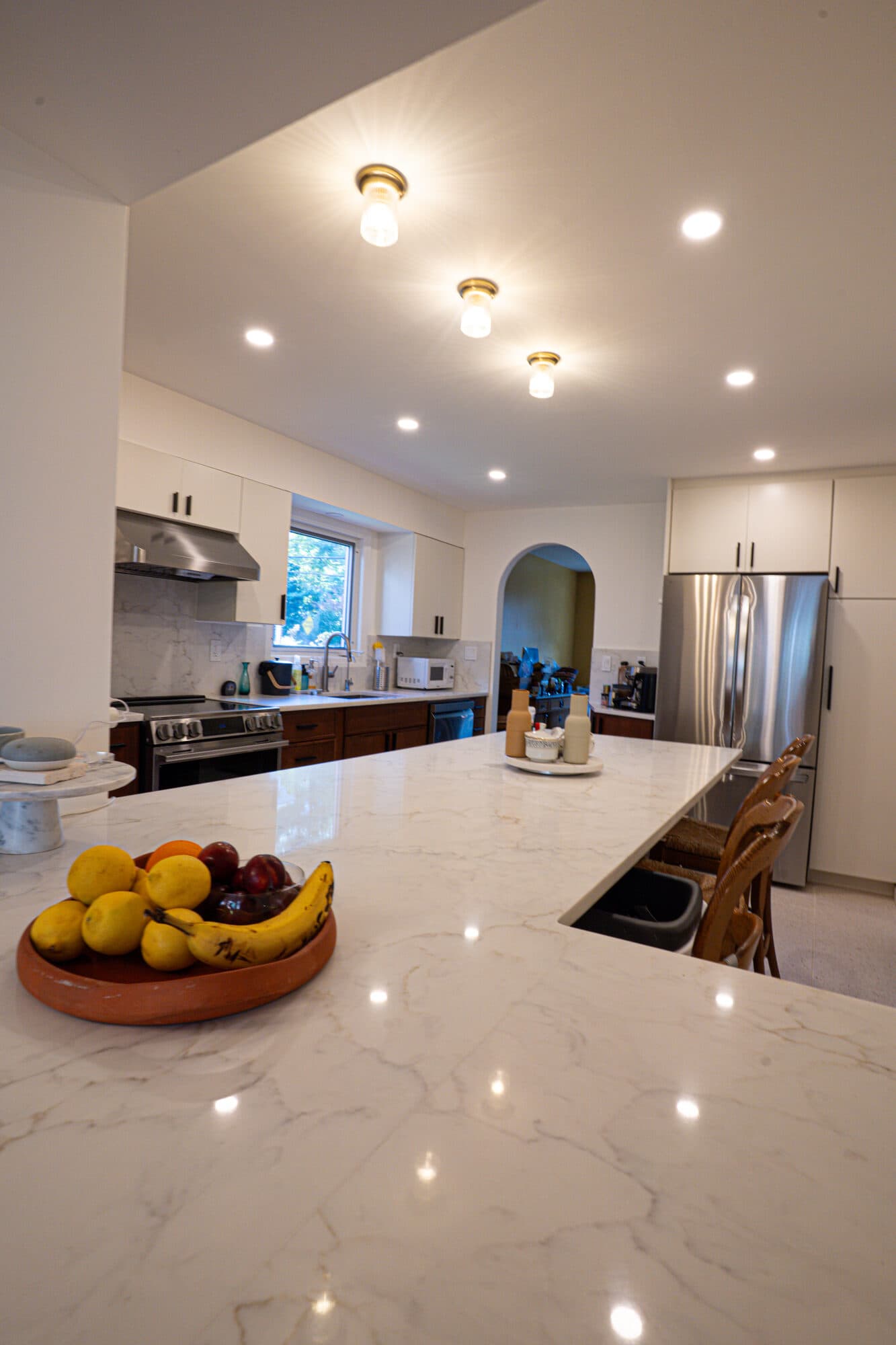 Renovated Riverdale kitchen with marble-look island counter and white upper cabinets