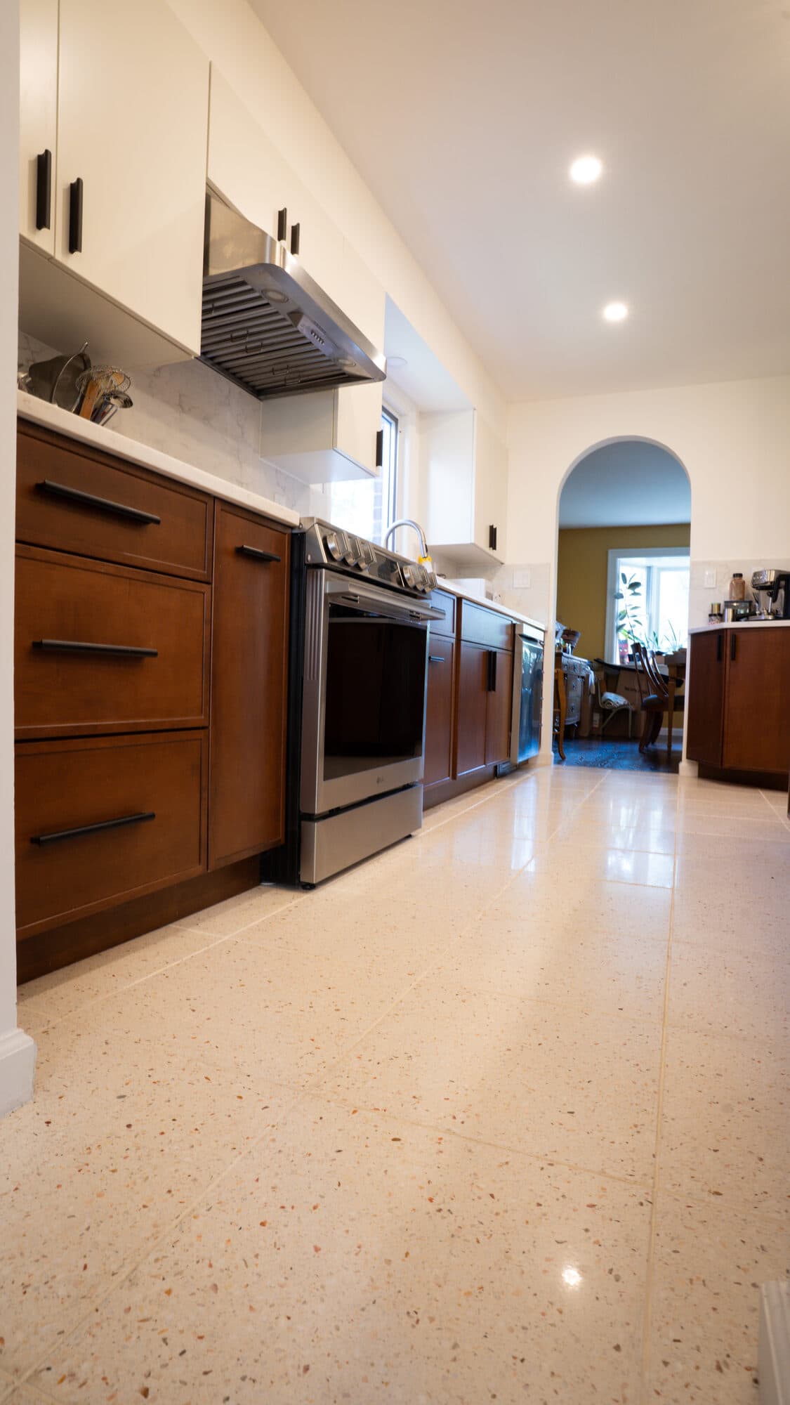 Range wall with wood-tone lower cabinets and white counters