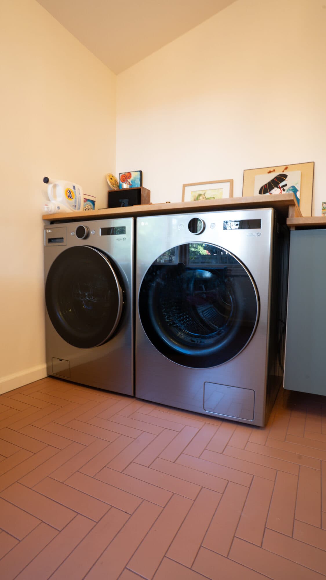 Washer and dryer on terracotta herringbone tile in the laundry area